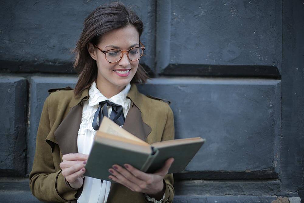 uśmiechnięta kobieta czyta książkę